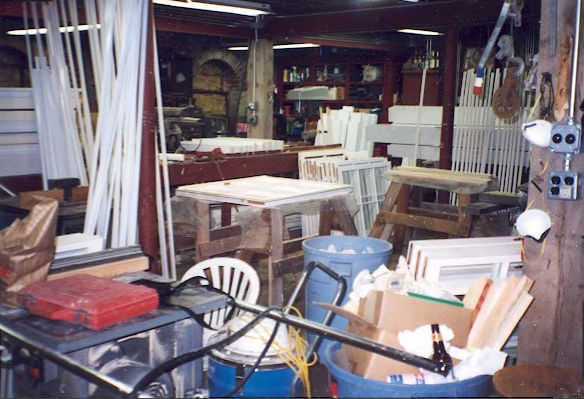 Basement workshop converted to window production — sash, muntin stock, and frame components